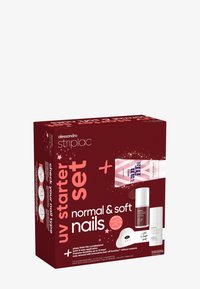 Emballage en boîte rouge avec du texte blanc et rose ; contient un kit de démarrage UV pour les soins des ongles avec une crème pour les mains, une lampe LED et divers produits pour les ongles.