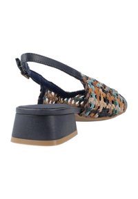 Zapato de slingback multicolor tejido que presenta un tacón cuadrado, tira de cuero y una parte superior texturizada con acentos en azul, marrón y crema.