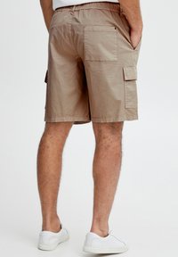 Beige cargoshorts med afslappet pasform, lavet af let stof. Har to sidelommer, en baglomme og en elastisk taljebånd.