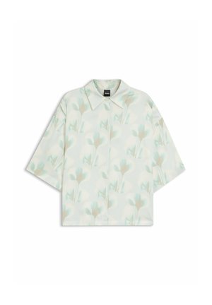 Chemise à manches courtes avec boutons et un motif floral pâle dans des tons doux de bleu et beige sur un fond clair.