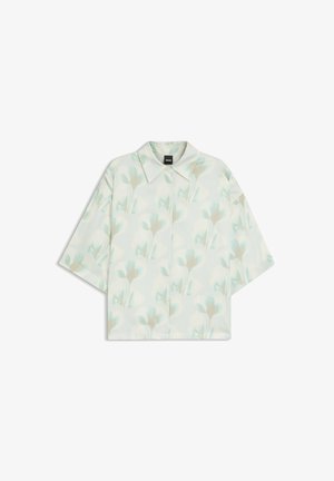 Kortærmet skjorte med knapper og et svagt blomsterprint i bløde blå og beige nuancer på en lys baggrund.