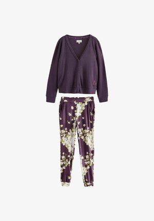 Cardigan violet cu dungi, cu decolteu în V și nasturi, asortat cu pantaloni cu model floral în nuanțe de violet, alb și verde.
