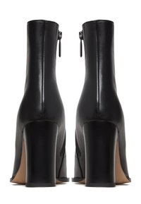 Zwarte leren enkelboots met een gestructureerd oppervlak, ronde neuzen en klompachtige hakken. Beschikt over een zijrits voor sluiting en een glad interieur.