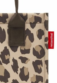 Borsa a spalla in tessuto con stampa leopardata beige e marrone scuro, con manici marrone scuro e etichetta rossa del marchio Reisenthel sul lato.