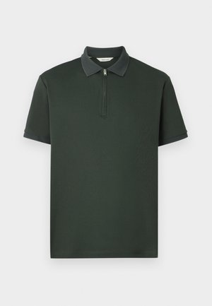 Polo de cor verde escuro com mangas curtas, gola com fecho éclair e acabamento em tecido texturizado contrastante na gola. Feito de um tecido suave com um design minimalista.