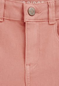 Rosa denimshorts med metallknapp-stängning, bältesöglor och kontrasterande sömmar, med en slät textur över tyget.