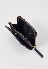 Black leather wallet with gold zipper, featuring multiple compartments and a textured finish. Notable interior branding and design details visible.