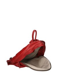 Sac en cuir rouge avec une texture lisse, une forme arrondie et une poignée supérieure ; il dispose d'une doublure beige et d'une fermeture éclair.