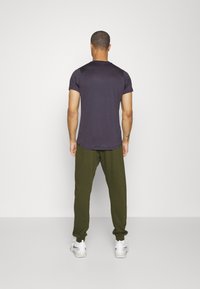 Nike Performance HERITAGE PANT - Calças de fato de treino - rough green