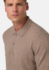 Šviesiai rudos spalvos, trumpomis rankovėmis polo marškinėliai, pagaminti iš minkštos medžiagos, turintys klasikinį apykaklę ir tris mygtukus su tamsiais mygtukais.