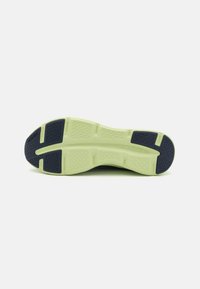 Semelle de chaussure de sport en deux couleurs : bleu marine foncé et vert lime. Présente des motifs texturés et un design segmenté pour une meilleure traction et un soutien optimal.