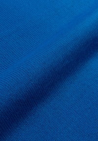Tessuto a maglia blu brillante caratterizzato da una trama liscia e un motivo uniforme di punti fini, con un colore omogeneo in tutto.