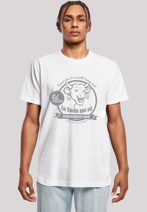 White cotton t-shirt featuring a gray graphic of a smiling cow with text "La Vache qui rit" and decorative accents. Relaxed fit.
