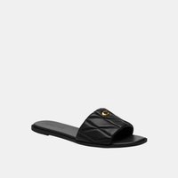 Black flat slide sandal with quilted strap and small gold-tone heart embellishment on top, open toe design.