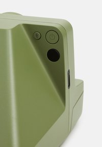 Green plastic device with a textured surface, featuring a power button, indicator light, and a small port on the side.