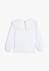 Weiße Bluse mit langen Ärmeln, die einen großen, gerafften Kragen mit gewellten Kanten und einen Knopfverschluss auf der Rückseite aufweist. Glattes Baumwollgewebe, minimaler Textur.