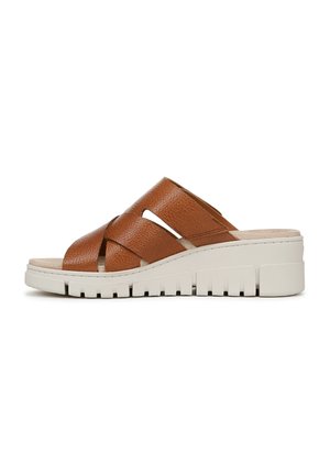 Sandali scivolati in pelle marrone con design a fascia incrociata, parte superiore testurizzata e una suola spessa bianca con un motivo rigato.
