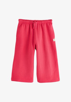 Crvene pamučne hlačice s elastičnim strukom i vezicom. Imaju dva bočna džepa i malu oznaku sa strane.