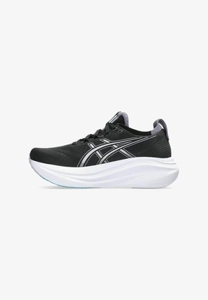 Baskets de sport noires avec une tige texturée, semelle intermédiaire blanche rembourrée et détails argentés sur les côtés. Elles présentent un bout rond et un système de laçage.