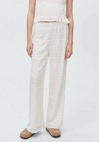 Witte, lichte, wijde broeken met een gestructureerd ruitpatroon, voorzien van een comfortabele elastische tailleband en een relaxte pasvorm.