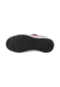 Suela de una zapatilla infantil con un dibujo de goma negra, patrones circulares y la marca "Geox", media suela blanca y parte superior en rojo y gris visible.