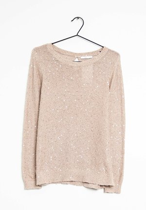 Pull beige tricoté à manches longues avec sequins, col rond, suspendu sur un cintre noir sur fond blanc.