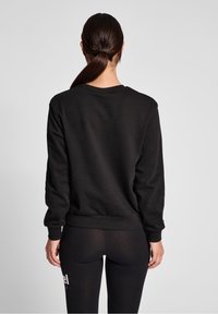 Sweat-shirt noir avec un col rond, des poignets et un ourlet côtelés. Le tissu semble lisse, avec une coupe décontractée et un minimum de détails.