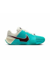 Zapatillas Nike turquesas con acentos en blanco y marrón, que presentan un llamativo diseño acanalado y una suela texturizada para un mejor agarre.