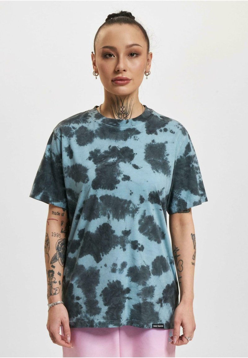 Heleheline puuvillane T-särk mustade tie-dye mustritega, lühikeste varrukatega, ümmarguse kaelusega ning väikese sildiga ääres.