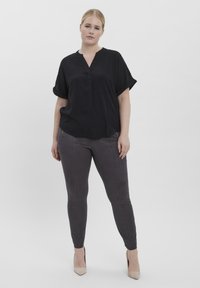 Zwarte blouse met korte mouwen en een V-hals, in combinatie met grijze slim-fit broek, met een gladde textuur en subtiele glans.