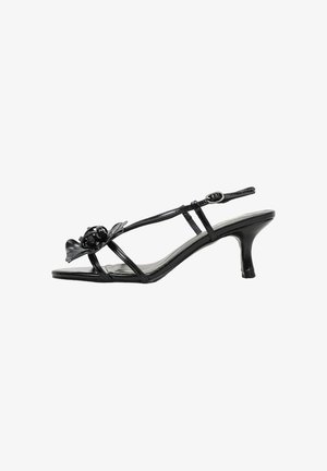 Sandale femme en cuir verni noir avec petit talon kitten, fines brides, boucle à la cheville et ornement floral décoratif sur la bride avant.
