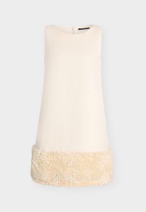 Robe droite sans manches de couleur crème avec encolure arrondie et détail texturé duveteux dans l’ourlet inférieur.