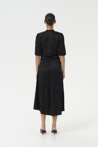 Black dress with short puff sleeves and a mid-length cut, featuring a textured fabric and a fitted waist that flows into a flared skirt.