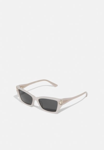 Square sunglasses with a translucent off-white frame, dark lenses, and gold accent at the temples. Matte texture, minimalist design.