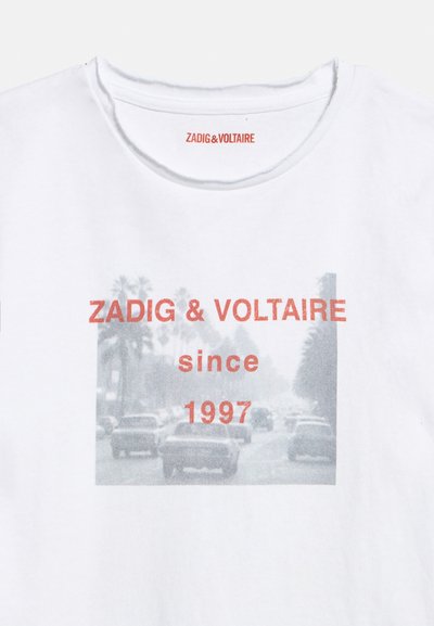 Λευκό T-shirt με ξεθωριασμένη ασπρόμαυρη φωτογραφία δρόμου πόλης και κόκκινο κείμενο "ZADIG & VOLTAIRE since 1997" στο εμπρός μέρος.