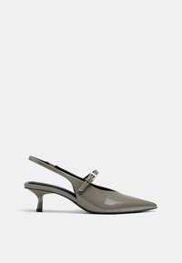 Chaussure slingback grise brillante à talon kitten avec bout pointu et petite boucle sur le côté, vue de profil sur fond blanc.