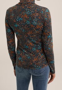 Dlouhá  rukávová blůza s tmavým pozadím a květinovým vzorem v odstínech tyrkysové a cihlové. Měkká, elastická tkanina s přiléhavým střihem.