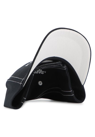 Μαύρο καπέλο με λευκή γείσο, που διαθέτει αντίθετη λευκή ραφή. Το εσωτερικό δείχνει μια απαλή υφασμάτινη επένδυση και ετικέτες με λογότυπο.