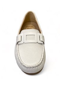 Białe skórzane mokasyny z teksturowaną powierzchnią, kwadratowym zapięciem na górze, widocznym szwem i beżową wyściółką wewnętrzną.