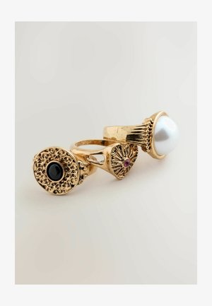 Kultainen monirengas, jossa on suuri valkoinen helmi, musta kivi ja koristeellinen kuvio pieniä vaaleanpunaisia kiviä. Raskas, teksturoidulla pinnalla varustettu rengas, jossa on koristeellisia yksityiskohtia.