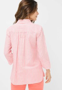 Collared shirt featuring pink and white vertical stripes, long sleeves, and a relaxed fit with a gathered back detail.