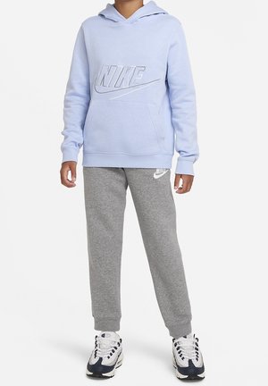 Jasnoniebieska bluza z kapturem Nike z przednią kieszenią i białym logo, zestawiona z szarymi spodniami dresowymi z małym logo i białymi trampkami.