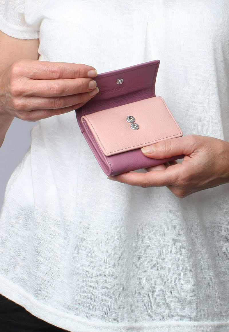 Portafoglio in pelle rosa e viola con chiusura a scatto, caratterizzato da due dettagli metallici tondeggianti sul davanti. Compatto, con una texture morbida.