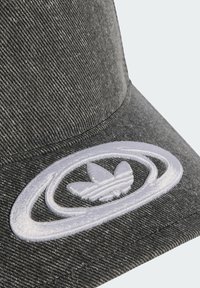 Šedá denimová čiapka s bielou vyšívanou logom a kruhovým dizajnovým prvkom vpredu. Textúrovaná látka s viditeľným detailom šitia.