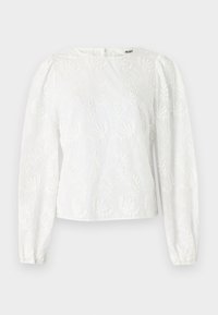 Blusa bianca con maniche lunghe a sbuffo, caratterizzata da motivi floreali ricamati e scollatura rotonda. Chiusura con zip sul retro.