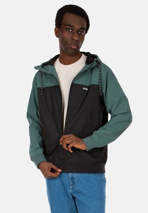 Black and green hooded jacket with zip closure, featuring drawstring accents, a contrasting upper, and ribbed cuffs, worn over a light shirt.