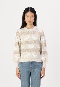 Beige gebreide trui met een fluffy textuur, voorzien van witte rendier- en sneeuwvlokpatronen. Geribbelde ronde hals en iets gepofte mouwen.