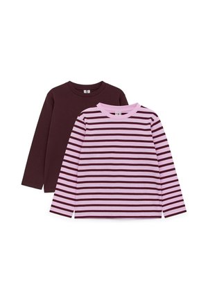 Deux chemises à manches longues pour enfants : une unie marron foncé, une rose avec des rayures horizontales marron foncé, posées à plat sur un fond blanc.