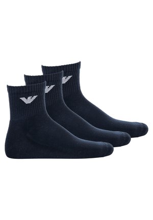 Chaussettes en coton bleu marine, avec des bords côtelés et un logo en blanc, présentées en lot de trois, d'une texture lisse et d'une longueur mi-mollet.