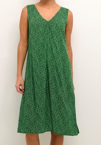 Vestido sin mangas verde con escote en V, con un patrón de print de leopardo negro y un diseño fluido que cae por debajo de la rodilla.